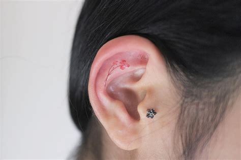 Tiny flower inner ear tattoo - Tattoogrid.net