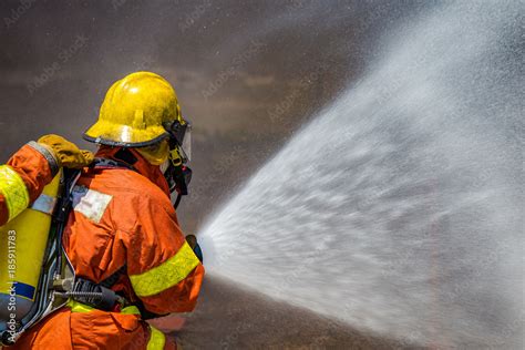 firefighter water spray by high pressure fire hose Stock Photo | Adobe ...