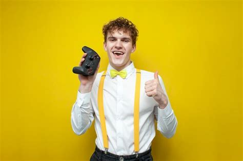 Premium Photo | Guy in festive outfit holds joystick nerd gamer in bowtie shirt and suspenders ...