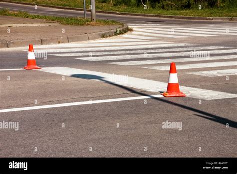 Work on road. Construction cones. Traffic cone, with white and orange stripes on asphalt. Street ...