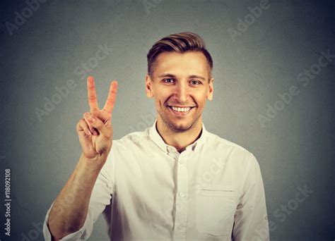 young handsome man holding up peace victory, two sign - Buy this stock photo and explore similar ...