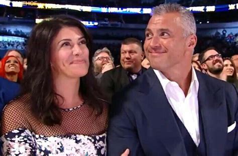 a man and woman sitting next to each other in front of an audience at a sporting event