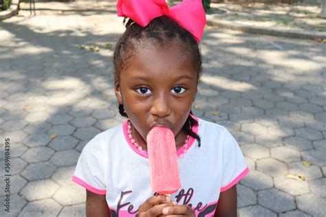 Little girl eating pink ice cream Popsicle Stock Photo | Adobe Stock