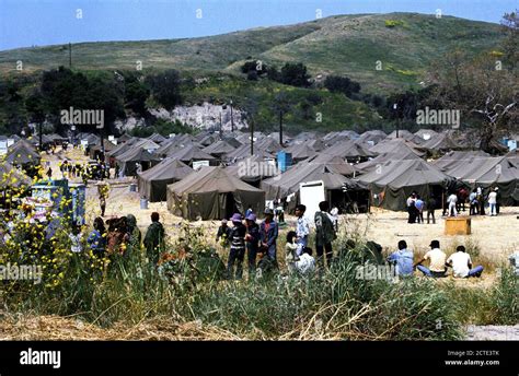 1975 - Vietnamese refugees at a temporary housing facility wait in line ...