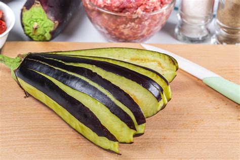 Sliced fresh eggplant on wooden kitchen board and ingredients for filling - Creative Commons Bilder