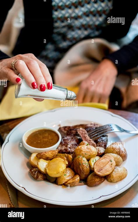 Woman salting meal Stock Photo - Alamy