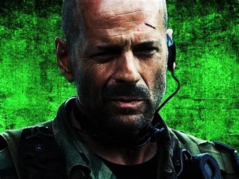 a man with a bald head wearing a headset in front of a green background