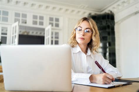 Premium Photo | Female manager working in office online report using laptop