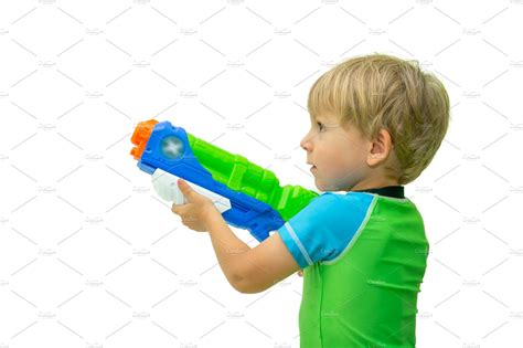 Boy holds water gun isolated on | High-Quality People Images ~ Creative Market