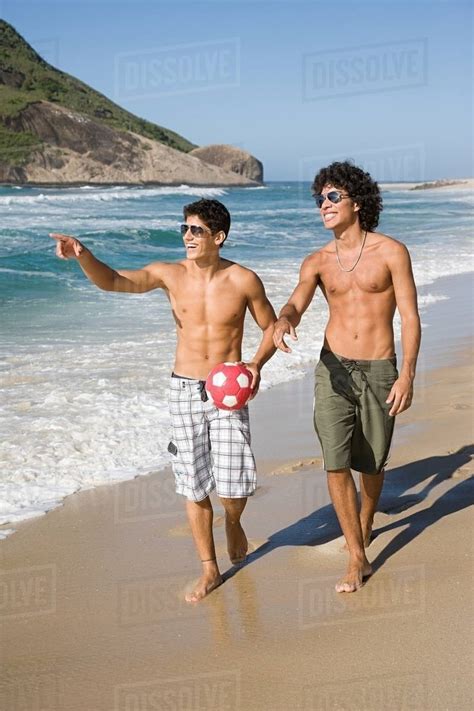 Teenage boys walking along a beach - Stock Photo - Dissolve