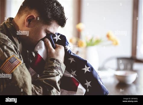 American soldier mourning and praying with the American flag in his ...