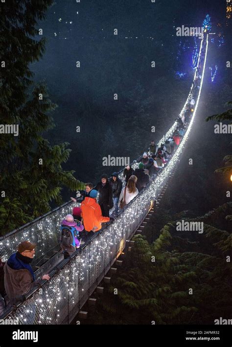 The illuminated Capilano Suspension Bridge at night with people ...