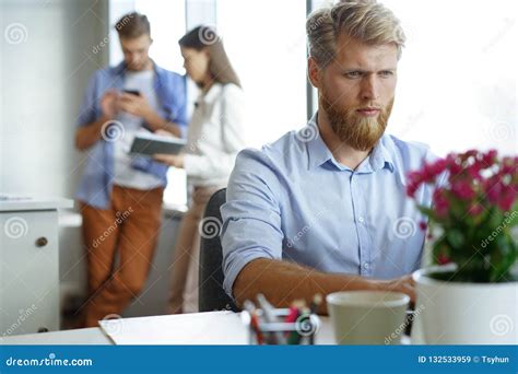 Portrait of Young Man Sitting at His Desk in the Office, Working on His Laptop. Stock Image ...