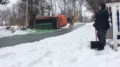 Snow plow flips on steep Massachusetts street