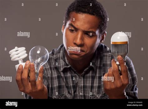 man holding two old and the newest generation of light bulbs Stock Photo - Alamy