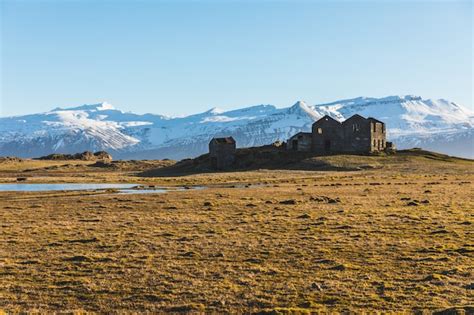 Premium Photo | Iceland bleak landscape, ruined house and mountains