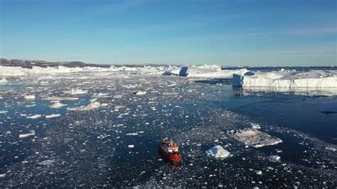 Environment. Cruise ship surrounded by icebergs and ice. Aerial view. Arctica. Greenland, Disco ...