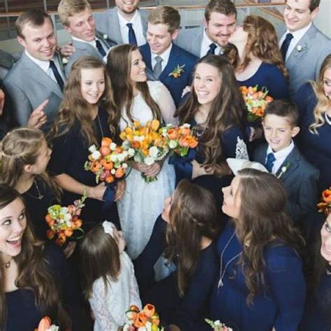 a large group of people standing next to each other with flowers in ...