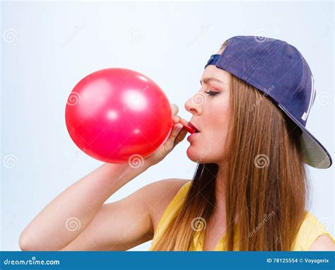 Teen Girl Blowing Red Balloon. Stock Photo - Image of inflating, decoration: 78125554