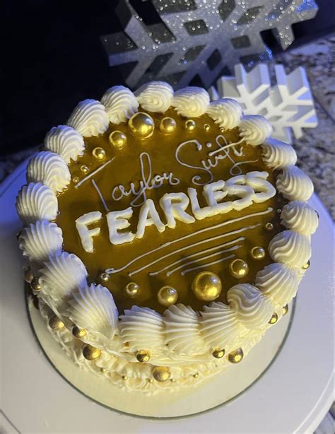 a cake with frosting that says fearless on it and snowflakes in the background