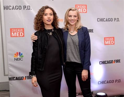 two women standing next to each other in front of a chicago mede sign on a red carpet