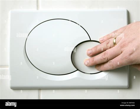 Hand pushing the low-flush button on a two button toilet flushing Stock Photo, Royalty Free ...