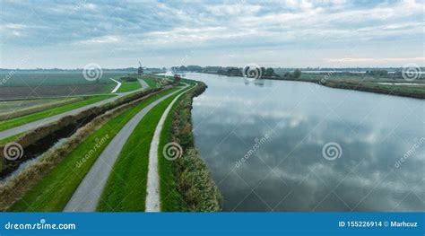 Typical Dutch Polder Landscape with Dykes and a Windmill Stock Photo ...