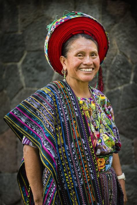 A Maya woman wears traditional dress, including tocoyal (headdress); the styles, patterns and ...