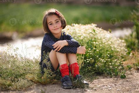 Little girl sitting in nature field wearing beautiful dress 4521116 Stock Photo at Vecteezy