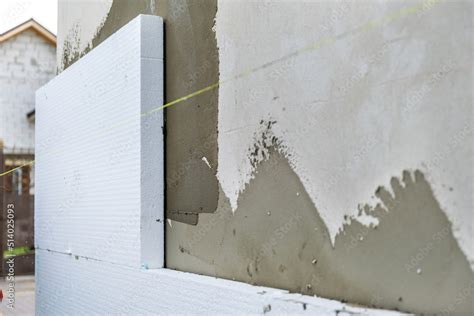 Installation of styrofoam insulation sheets on house facade wall for ...