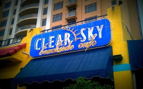 a blue and yellow building with a sign that says clear sky