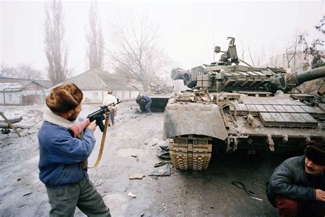 Chechen fighters investigate a destroyed convoy of Russian vehicles ...