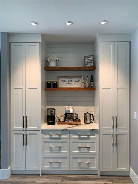 a kitchen with gray cabinets and white counter tops, coffee maker on ...