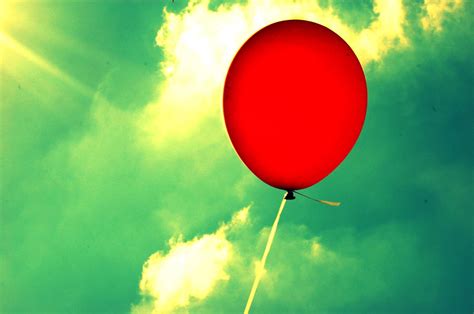 Red Balloon Floating In Sky With Sun by Meredith Winn Photography