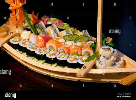 Assortment of Sushi on a wooden boat shaped platter including: Sushi Stock Photo, Royalty Free ...