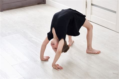 Premium Photo | Little girl doing backbend gymnastics exercise at home