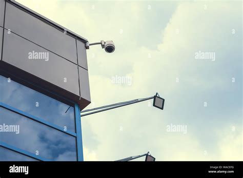 Surveillance camera on the corner of the house. Security and control Stock Photo - Alamy