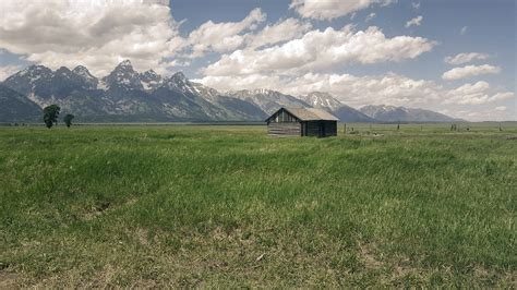 Beautiful Landscape with grassland and Mountains with Cabin under sky and clouds image - Free ...