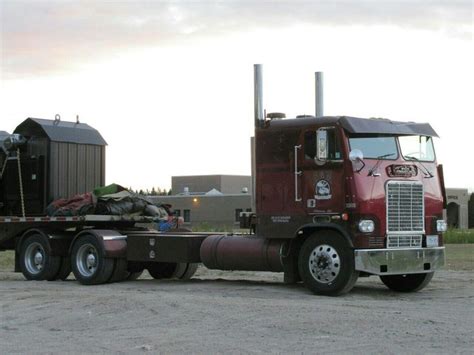 a large semi truck with a trailer hauling logs