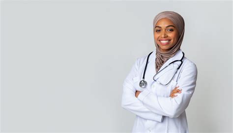 Portrait Of Smiling Black Female Doctor In Hijab And White Coat - Linguava