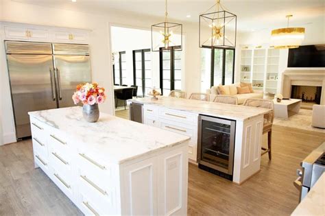 a large kitchen with an island in the middle and a stove top oven on the other side