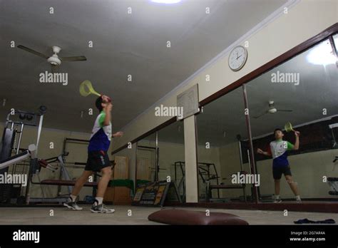 A young badminton athlete is practising various strokes and footsteps ...