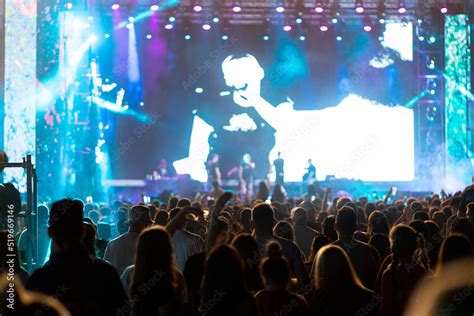 Large group of people in front of a music festival stage. Crowd is ...