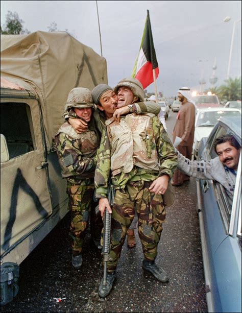 A Kuwait City resident hugs two US Marines after Allied troops ...