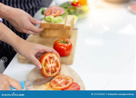 Beautiful Mom is Chopping Tomato by Using Knife on Cutting Board Stock ...