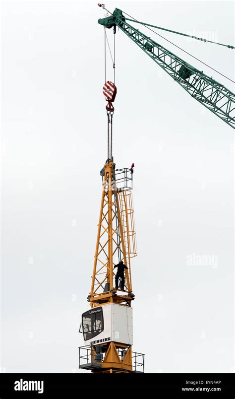 Construction worker dismantling tower crane Stock Photo - Alamy