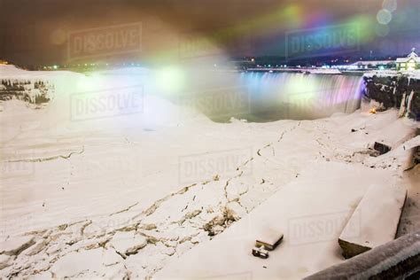 Frozen Niagara Falls in March illuminated at night, Niagara, Ontario, Canada, North America ...