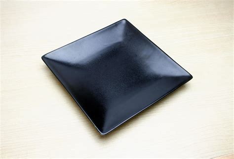 Black square plate on table 1960105 Stock Photo at Vecteezy