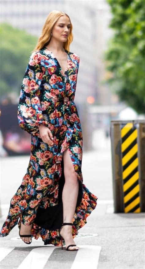 a woman is walking down the street in a floral dress