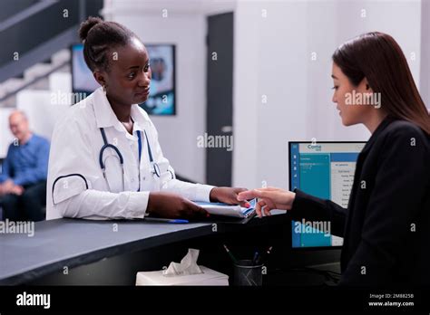 Receptionist helping physician doctor with checkup visit appointments ...